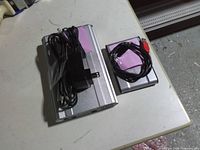 Two external hard drives on table, cables and adapter visible