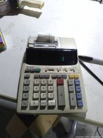 Front view showing keys, display and paper roll