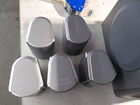 Top view of five satellite speakers showing shape and Center Speaker label