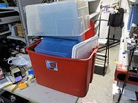 Stack of four plastic totes, red Sterilite outer with three smaller totes inside
