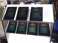 Front view showing all seven volumes on two-tier shelf
