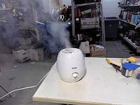 Humidifier emitting mist on tabletop