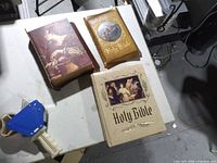 Three Bibles on table: brown, gold, beige
