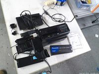 Camcorder, battery, charger, cables, manuals spread on table