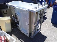 Side view showing door, exterior frame, plumbing and pump