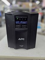 Front view showing APC logo, Smart-UPS 1000 model name and LCD screen indicating load 0 % battery 73 %