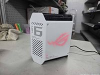 Front view showing WiFi branding, pink ROG logo, ventilation grille and power indicator