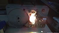 Front view showing reel arm area, lamp illuminated, control panel