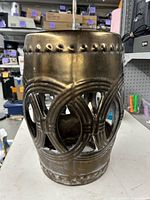 Front view of bronze ceramic garden stool with pierced circle pattern