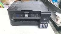 Front view of Epson ET-2750 showing control panel, output tray and ink tanks