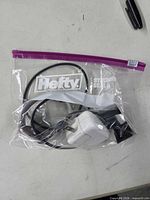 Fitbit charging cable and Apple wall adapter sealed in plastic bag
