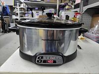 Front view of Hamilton Beach digital slow cooker showing stainless housing, control panel, side handles and lid
