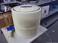 Front view Honeywell cylindrical air cleaner showing grille and brand logo