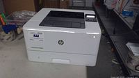 Front-angle view of HP LaserJet Pro M402n printer powered on