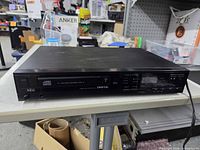 Front and top view of NEC CD player showing disc tray, controls, headphone jack and branding