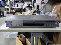 Front view showing Samsung branding, disc tray, controls and Dolby/DTS logo
