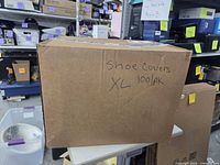 Cardboard box labeled 'Shoe Covers XL 100/pk'