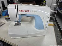 Front and side view of Singer Simple portable sewing machine showing overall condition