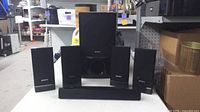 Front view showing subwoofer, four satellites and center speaker