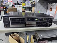 Front view showing Sony branding, cassette well, control buttons, LED meters, and function sliders