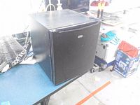 Front view of black Sunbeam mini fridge on table