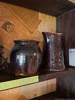 Small open-mouth crock jar and tall pitcher on shelf