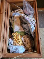 Top view of storage chest showing mixed folded linens in various colours and patterns