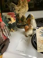 Group of rooster figurines on stovetop with plate
