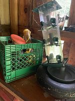 Overall lot: crate with tools and feeders, tube feeder resting in tire