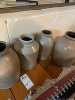 All four gray salt-glazed crocks standing side by side with measurement card