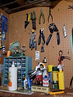 Pegboard with multiple hand tools, drawer organizer, aerosols visible