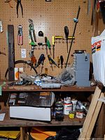 Overall pegboard wall with tools, belt sander box, drawer organizer