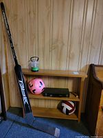Overall lot: shelf with lantern, soccer ball, cue case, volleyball, hockey stick