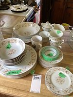Stack of dinner plates, salad plates, soup bowls, large serving bowl, sugar, creamer, cups and saucers on countertop