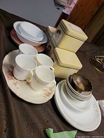 Overall view of dinnerware, mugs, bowls, platter and canisters