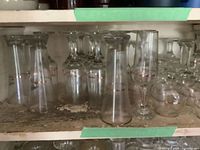 Shelf with multiple clear stemware pieces showing gold rims and assorted shapes