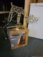 Tree box, wire reindeer frame, coil of blue lights