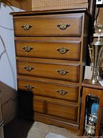 Front view showing five drawers and brass-tone pulls