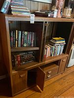 Front view of entertainment center showing shelves, glass doors, drawers, cabinets