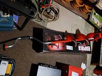 Auger assembled beside original box showing handle and red flights