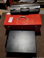 Overall view of red toolbox, black briefcase and black parts box stacked