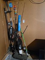 Group of rods, nets and tackle case against pegboard