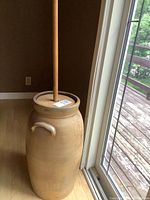 Full view of stoneware butter churn with dasher