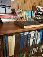 Shelf with pastel-spined children’s hardcovers and glass-cabinet books below