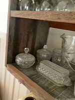 Round and oval covered dishes, butter dish, pitcher partial view