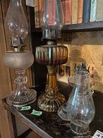 Group shot of all three vintage oil lamps on shelf