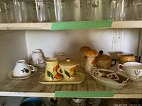 Shelf with entire assortment of porcelain items and mushroom figurines