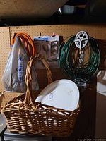 Overall view of basket, platter, wire spool, pulleys, rope, and screw hooks on pegboard