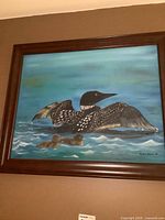 Full view of framed loon painting on wall