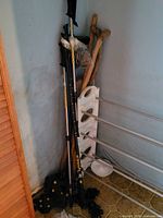 Corner grouping of trekking poles, wooden sticks, baskets visible